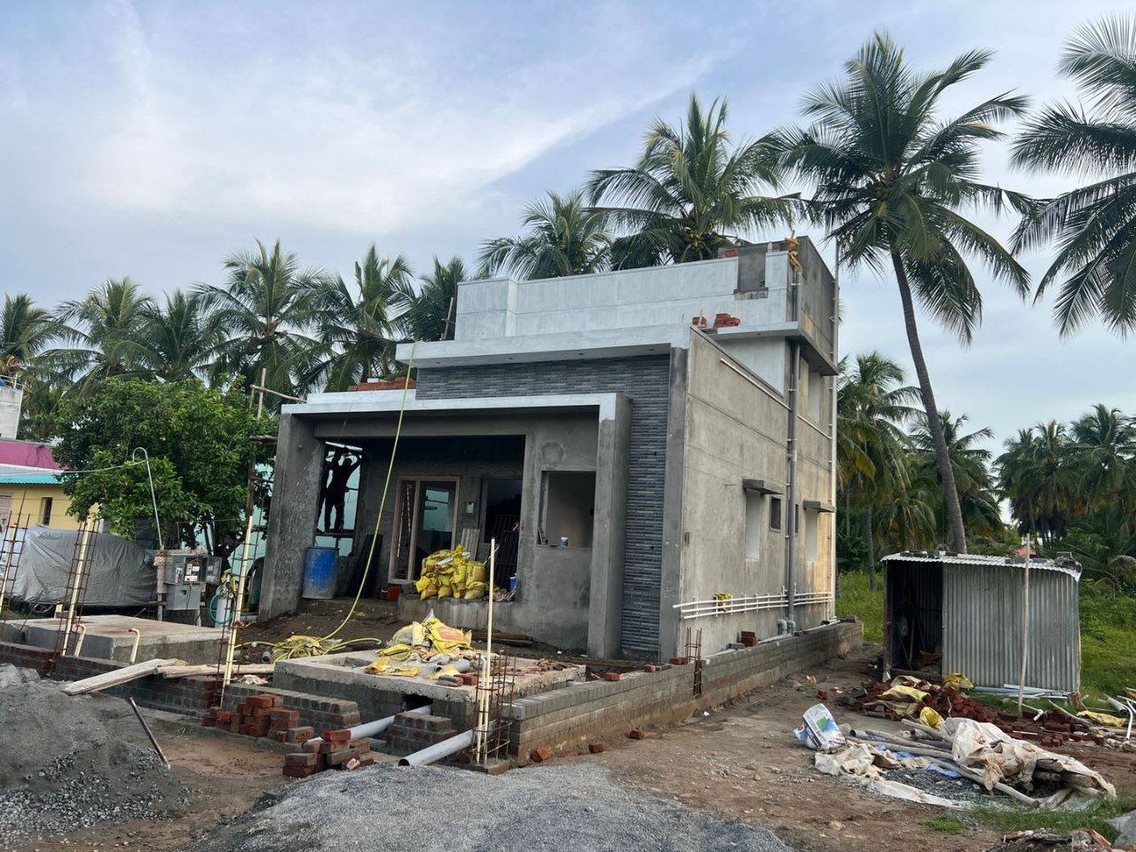 Front elevation of a newly built house with lush green surroundings in Salem